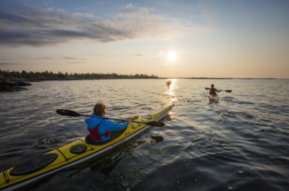 Kayakers paddling into the sunset at White Squall Paddling Centre